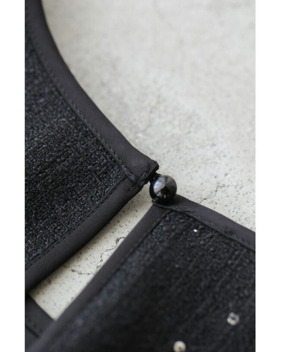 A dress with a tweed-like top and a glossy skirt, sparkling with sequins