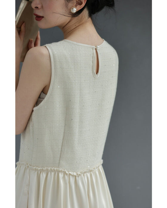 A dress with a tweed-like top and a glossy skirt, sparkling with sequins