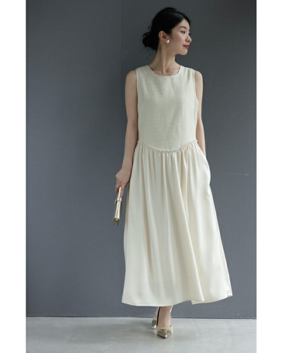 A dress with a tweed-like top and a glossy skirt, sparkling with sequins