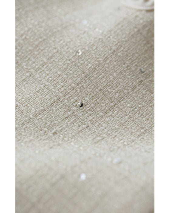 A dress with a tweed-like top and a glossy skirt, sparkling with sequins