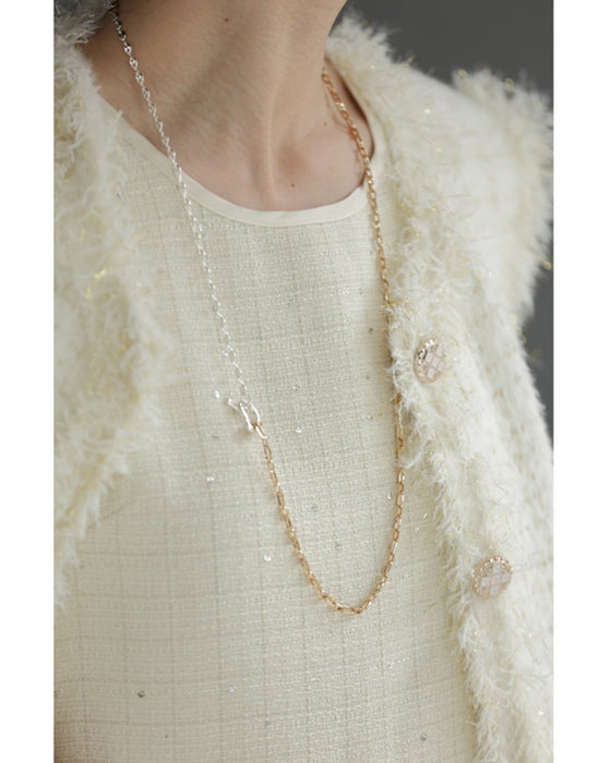 A dress with a tweed-like top and a glossy skirt, sparkling with sequins