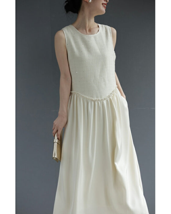 A dress with a tweed-like top and a glossy skirt, sparkling with sequins