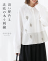 A blouse with pale colors and embroidered Nordic trees