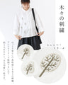 A blouse with pale colors and embroidered Nordic trees