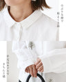 A blouse with pale colors and embroidered Nordic trees