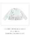 A blouse with pale colors and embroidered Nordic trees