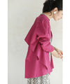 A collared shirt top with ruffles flowing from the back