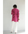 A collared shirt top with ruffles flowing from the back
