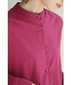 A collared shirt top with ruffles flowing from the back