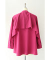 A collared shirt top with ruffles flowing from the back