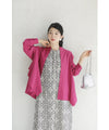 A collared shirt top with ruffles flowing from the back