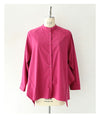 A collared shirt top with ruffles flowing from the back