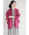 A collared shirt top with ruffles flowing from the back