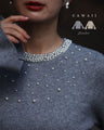 A bell-sleeve knit top with pearls falling all over it