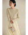 A bell-sleeve knit top with pearls falling all over it