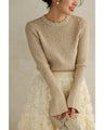A bell-sleeve knit top with pearls falling all over it