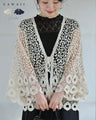 A teardrop-shaped knit lace cardigan with a flared hem