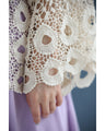 A teardrop-shaped knit lace cardigan with a flared hem