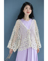 A teardrop-shaped knit lace cardigan with a flared hem
