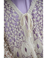 A teardrop-shaped knit lace cardigan with a flared hem