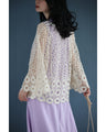 A teardrop-shaped knit lace cardigan with a flared hem