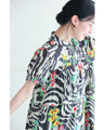 A long dress with a pop floral pattern overlapping with swaying art