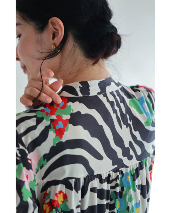 A long dress with a pop floral pattern overlapping with swaying art