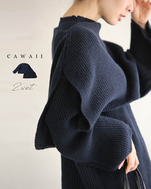  A two-piece set consisting of a loose knit top and a knit cape.