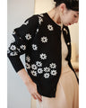 A knitted cardigan with falling white flowers
