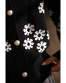 A knitted cardigan with falling white flowers