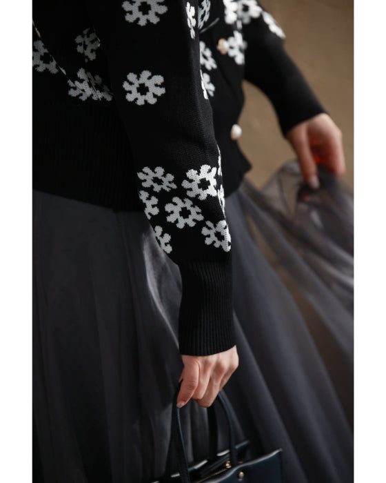 A knitted cardigan with falling white flowers