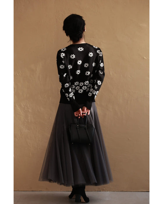 A knitted cardigan with falling white flowers