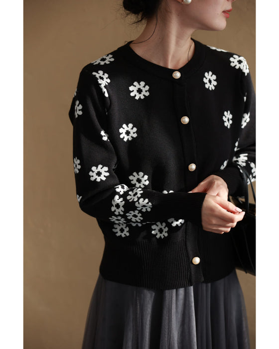 A knitted cardigan with falling white flowers