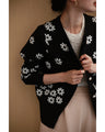 A knitted cardigan with falling white flowers