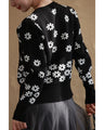 A knitted cardigan with falling white flowers