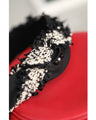 A twisted headband made of different materials and decorated with jewels