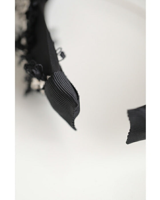 A twisted headband made of different materials and decorated with jewels