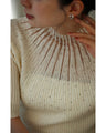 A streamlined ribbed cut-and-sew top with light particles falling on it