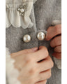 A pearl button coat with sparkling beaded daisy frills
