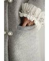 A pearl button coat with sparkling beaded daisy frills
