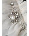 A pearl button coat with sparkling beaded daisy frills