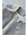 A pearl button coat with sparkling beaded daisy frills