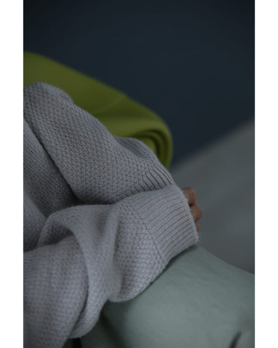 アシンメトリーなシアーデコルテの白花ニットプルオーバートップス