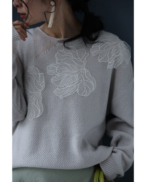 アシンメトリーなシアーデコルテの白花ニットプルオーバートップス