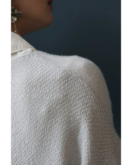 アシンメトリーなシアーデコルテの白花ニットプルオーバートップス