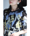 A sheer floral mid-length dress with pleats that flares out from the neck