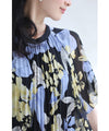 A sheer floral mid-length dress with pleats that flares out from the neck