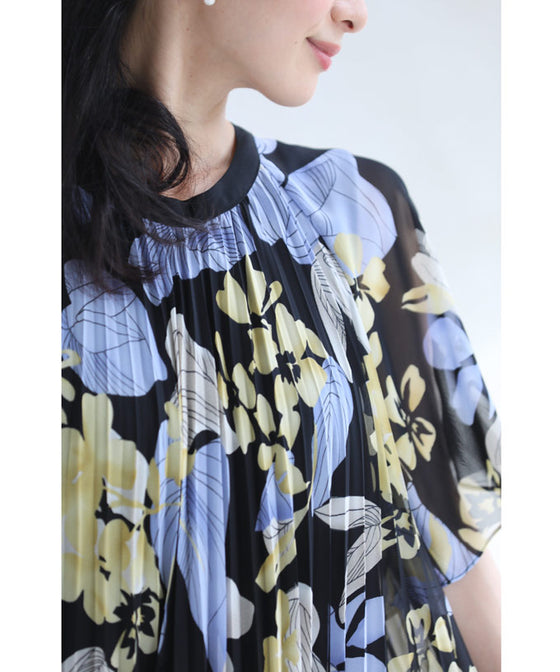 A sheer floral mid-length dress with pleats that flares out from the neck