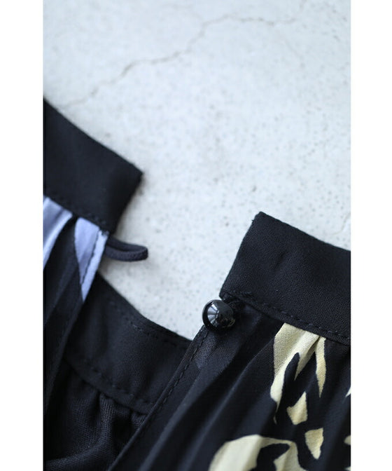 A sheer floral mid-length dress with pleats that flares out from the neck