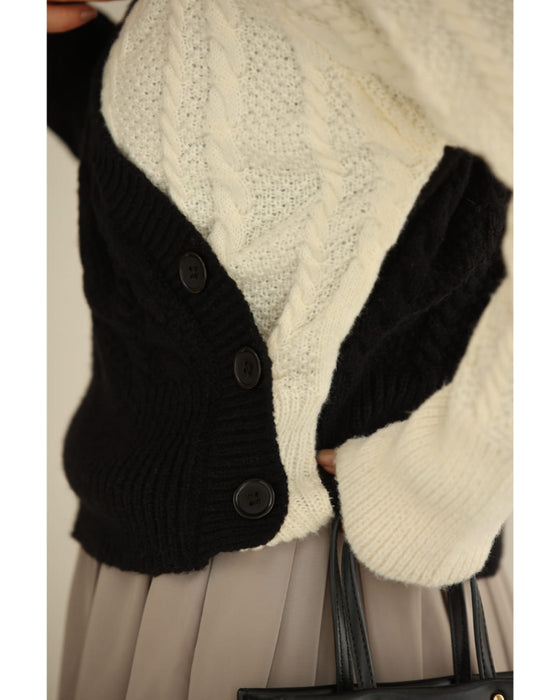 A knit pullover top with a black and white cache-coeur design
